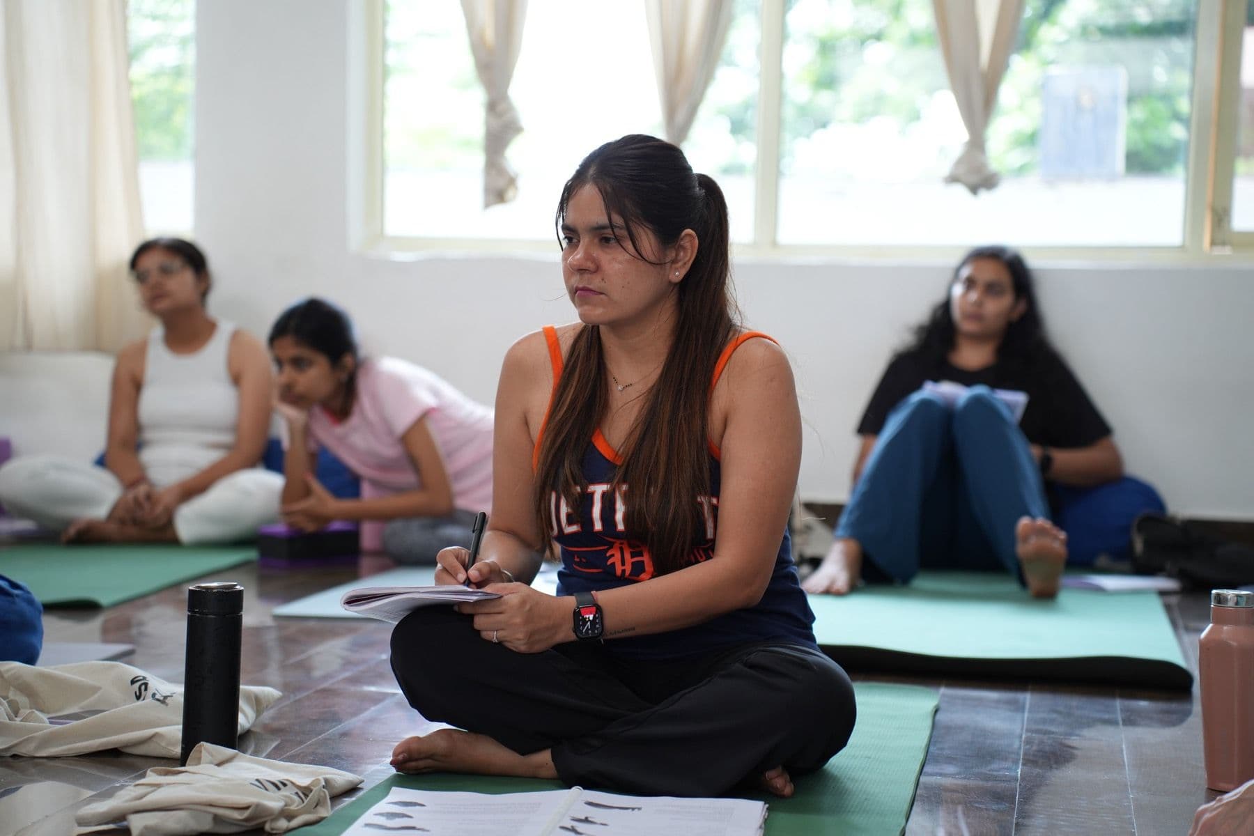 Shilpa seated, taking notes during a session