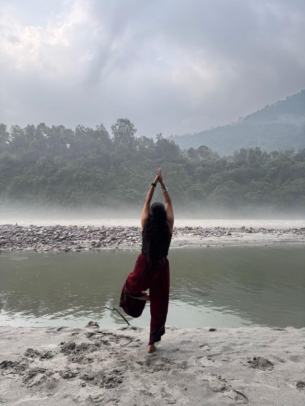 Shilpa standing in a quiet riverside posture